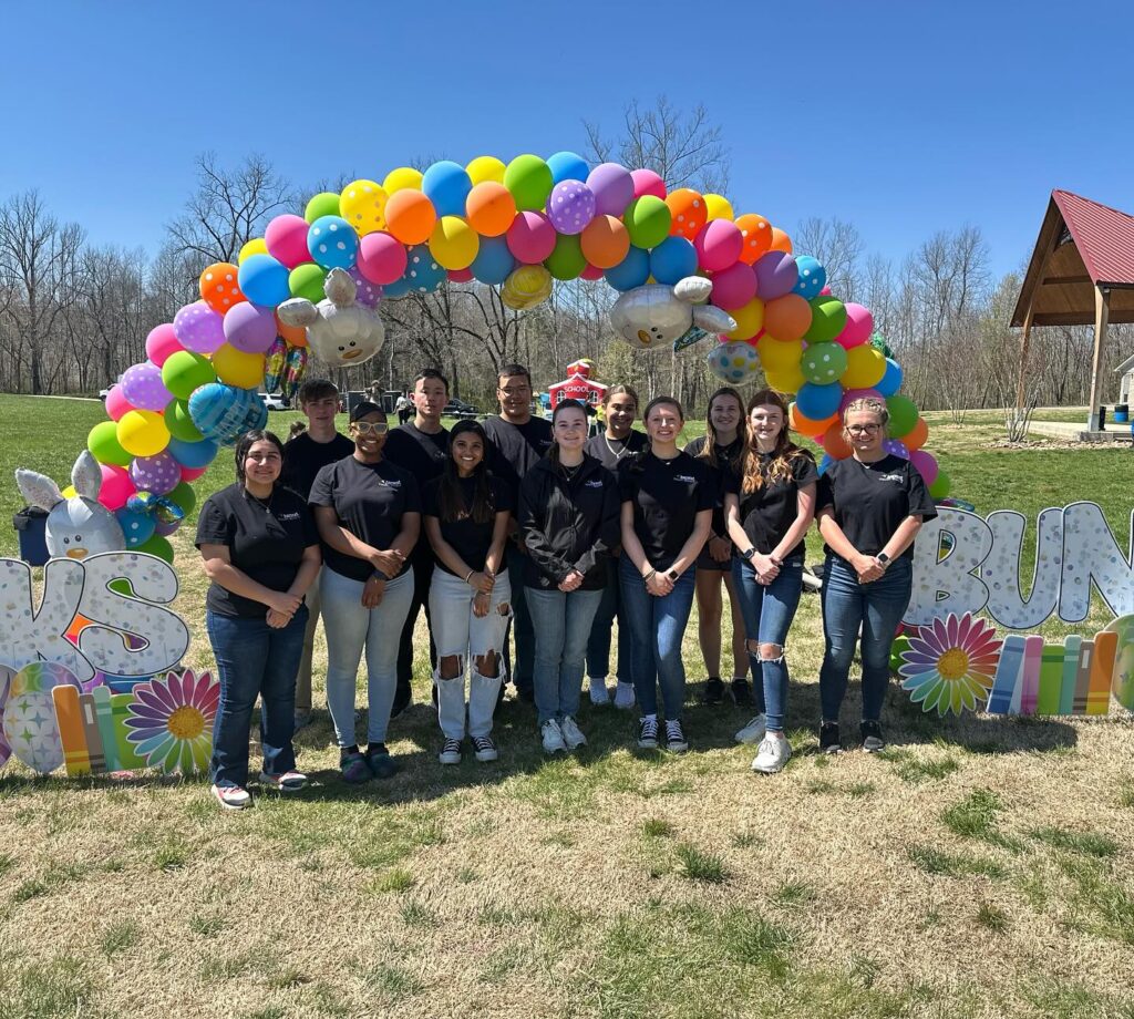 teenagers underneath a balloon archway 