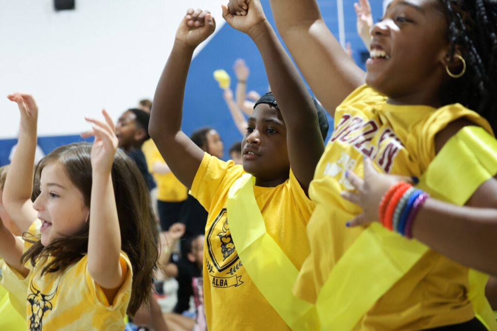students at school dancing in yellow shirts