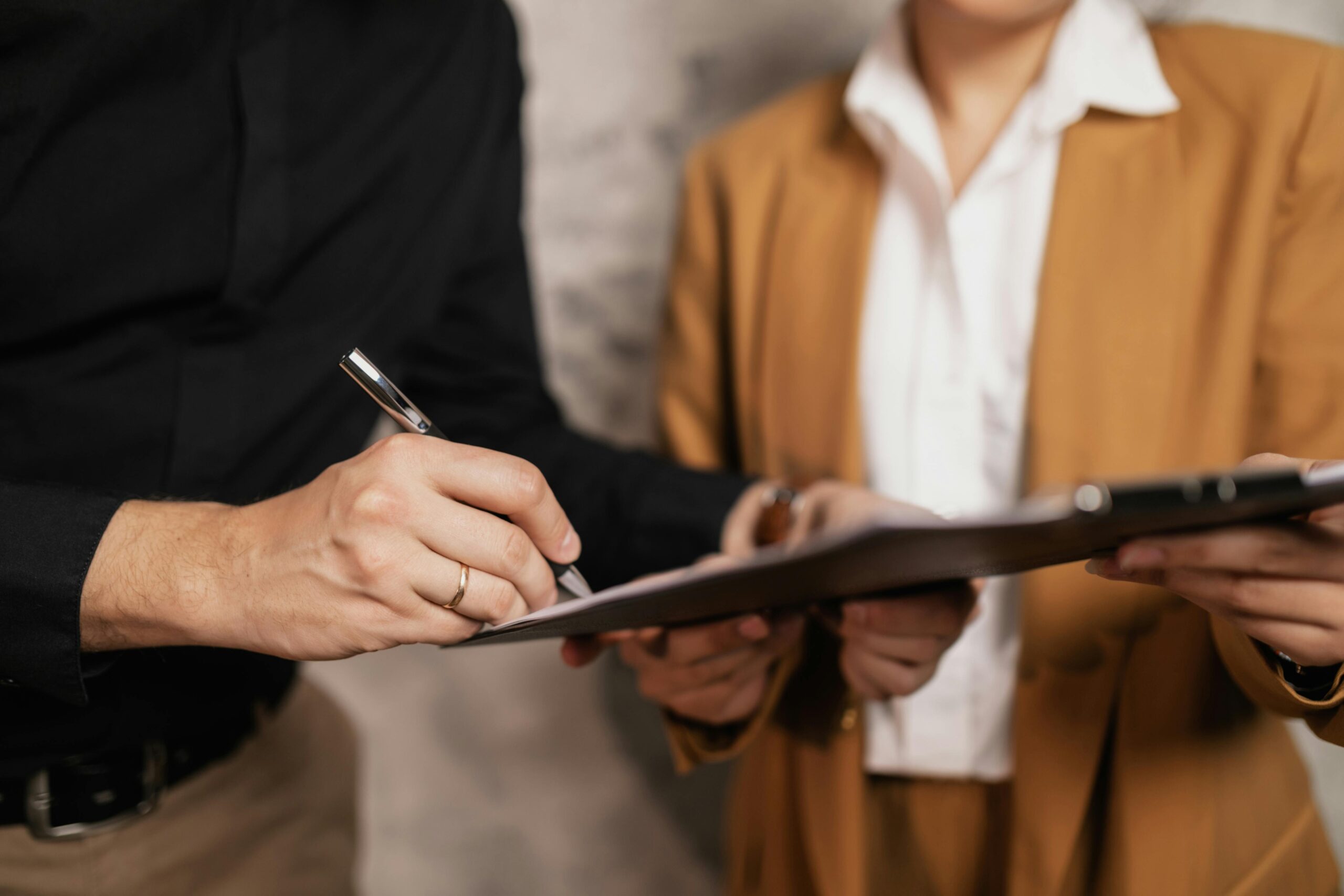 person holding clipboard while another signs up for newsletter