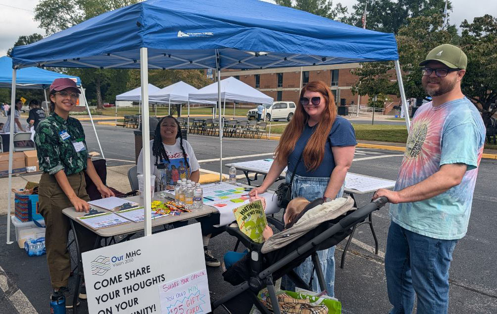 Our MHC Community Liaison Jordan Menefee speaks with a family at the 7th Festival Latino of Southern Virginia at Patrick & Henry Community College